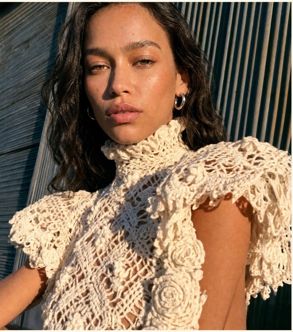 Close portrait of a model in a cream crochet ruffle top